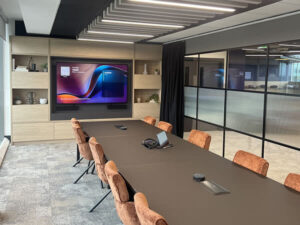 Wide shot of Synextra’s executive boardroom with large display, Teams Room technology and modern AV integration by Rapid Technologies.