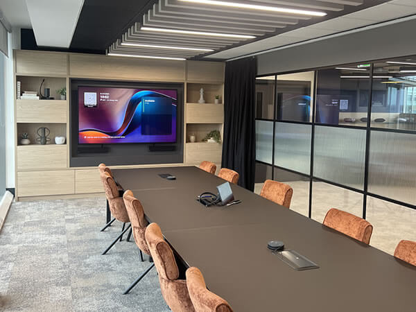 Wide shot of Synextra’s executive boardroom with large display, Teams Room technology and modern AV integration by Rapid Technologies.