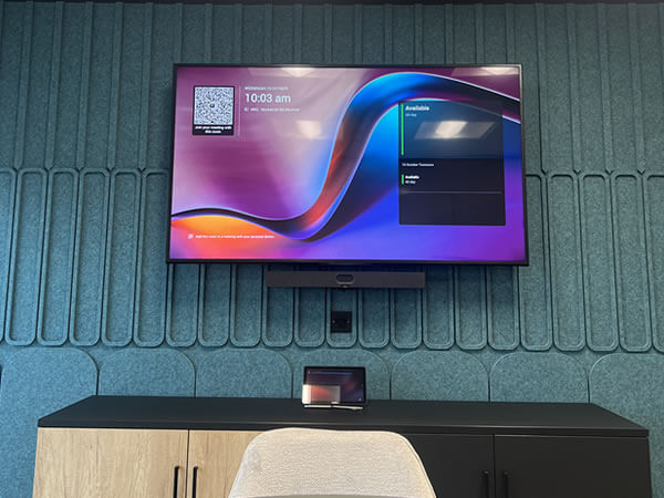 Close-up of wall-mounted Sony display and Yealink touchscreen controller in Synextra’s Teams Room setup.