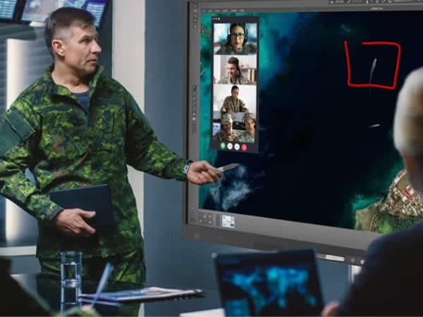 Military briefing using interactive touchscreen display with video conferencing for remote command collaboration.